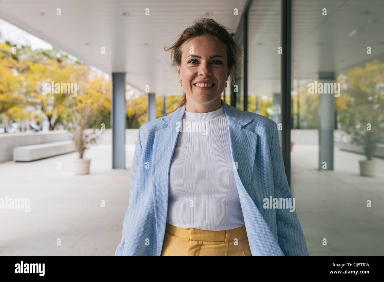 Smiling businesswoman wearing blue blazer Stock Photo