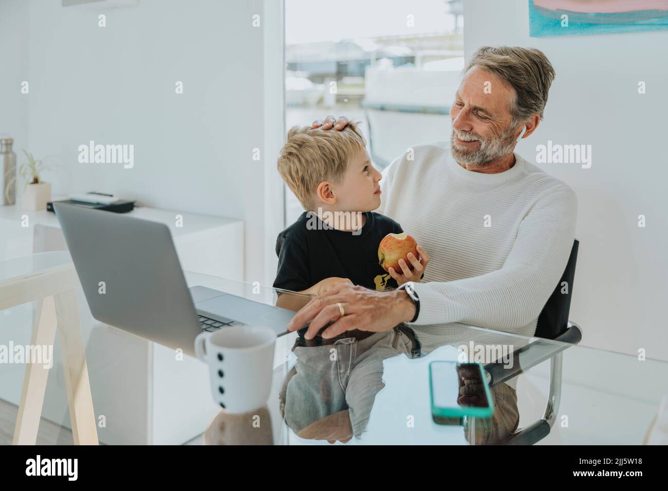 Happy father with son sitting at table Stock Photo
