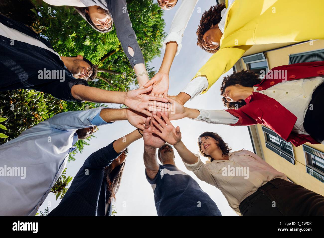 Businessmen and businesswomen stacking hands Stock Photo
