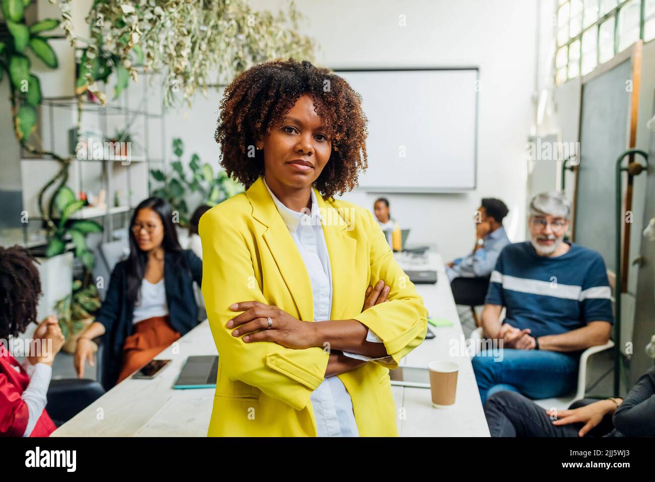 Confident businesswoman with arms crossed in office Stock Photo - Alamy