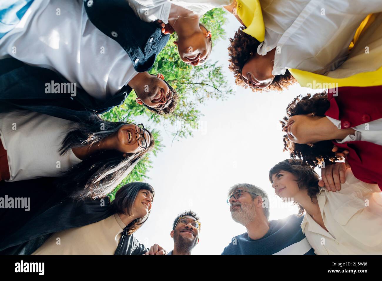 Smiling multiracial business colleagues huddling together Stock Photo