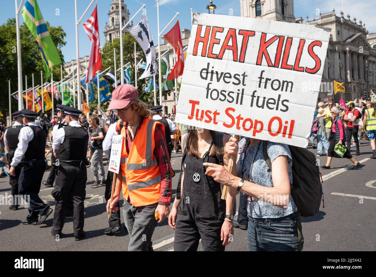 London, UK. 23rd July 2022. We All Want To Just Stop Oil Coalition: National March & Sit Down. One of many marches that converged upon Westminster. Protesters in Parliament Square holding Heat Kills divest from fossil fuels Just Stop Oil placard. Credit: Stephen Bell/Alamy Live News Stock Photo