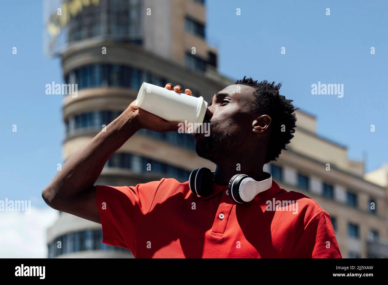 Man drinking coffee from disposable cup on sunny day Stock Photo