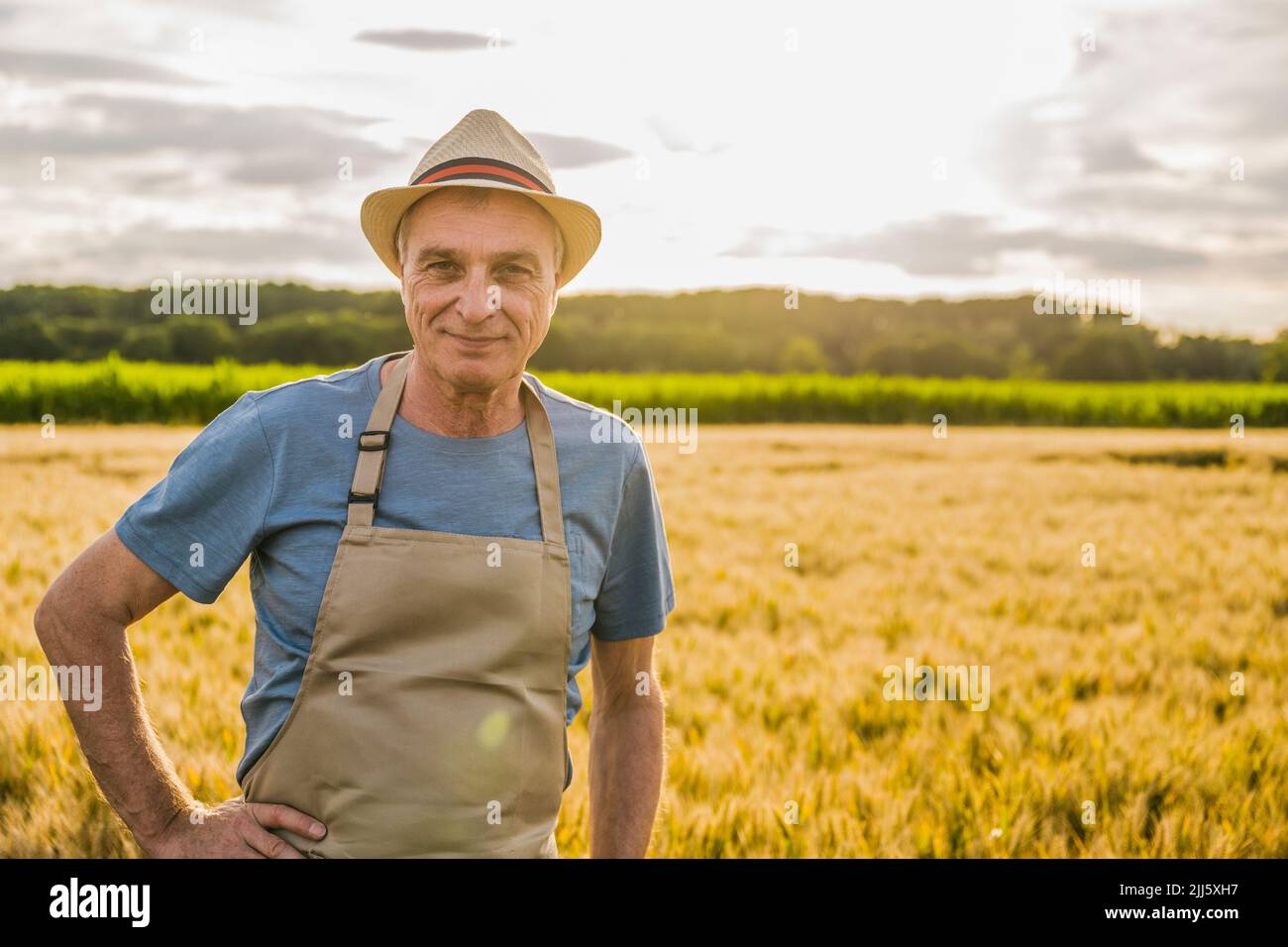 Smiling farmer wearing apron standing in farm Stock Photo