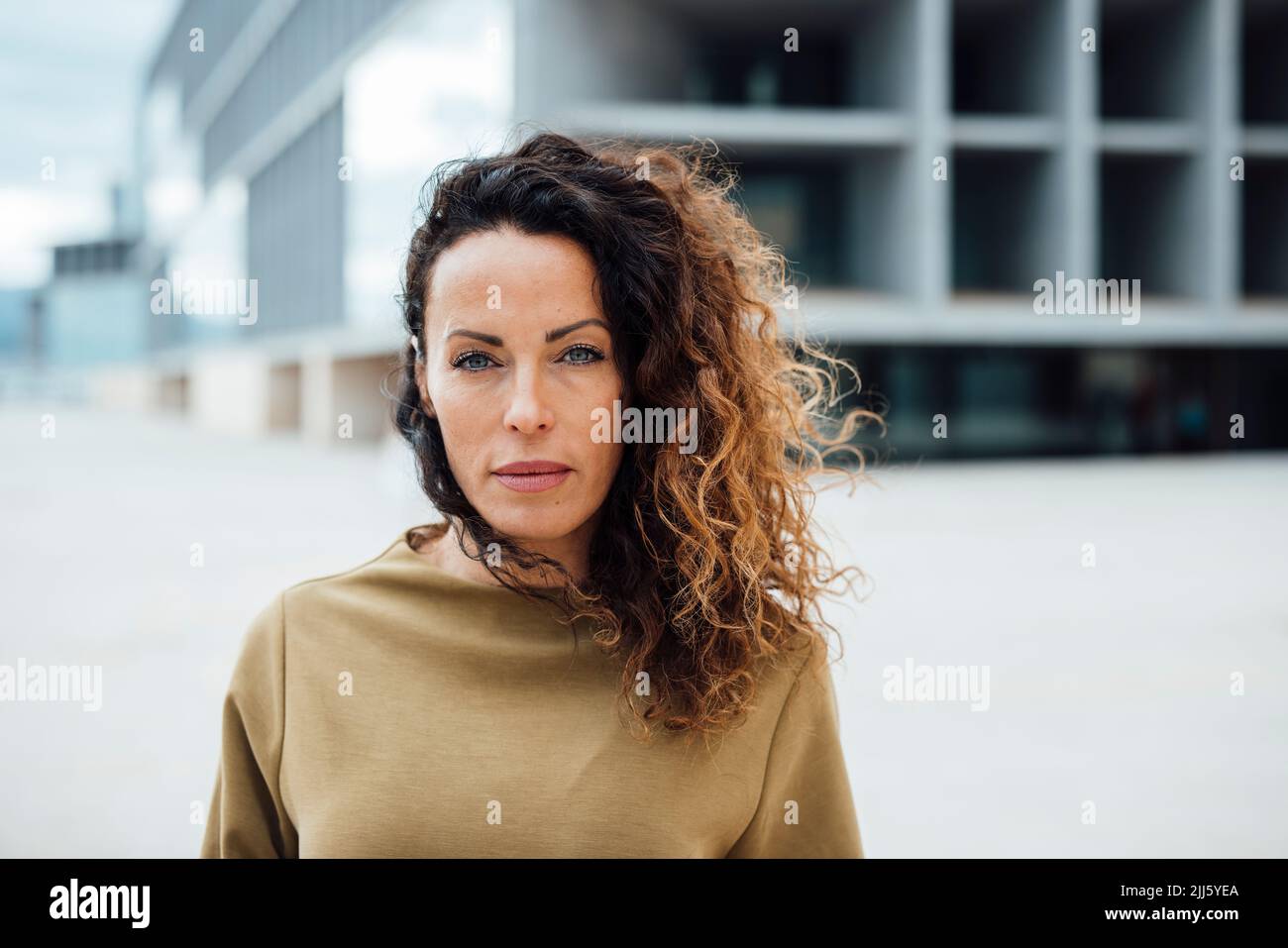 Confident businesswoman with curly hair Stock Photo