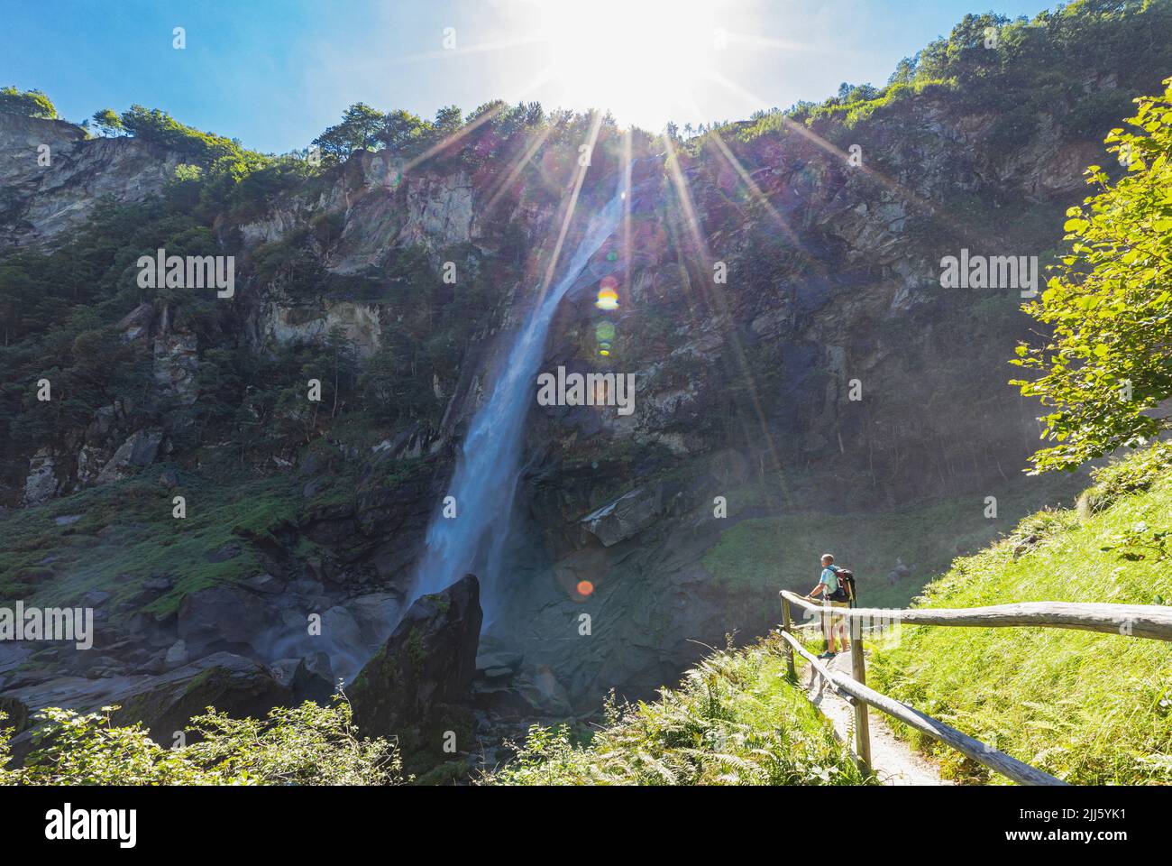 Senior man hiking near Foroglio waterfall on sunny day Stock Photo