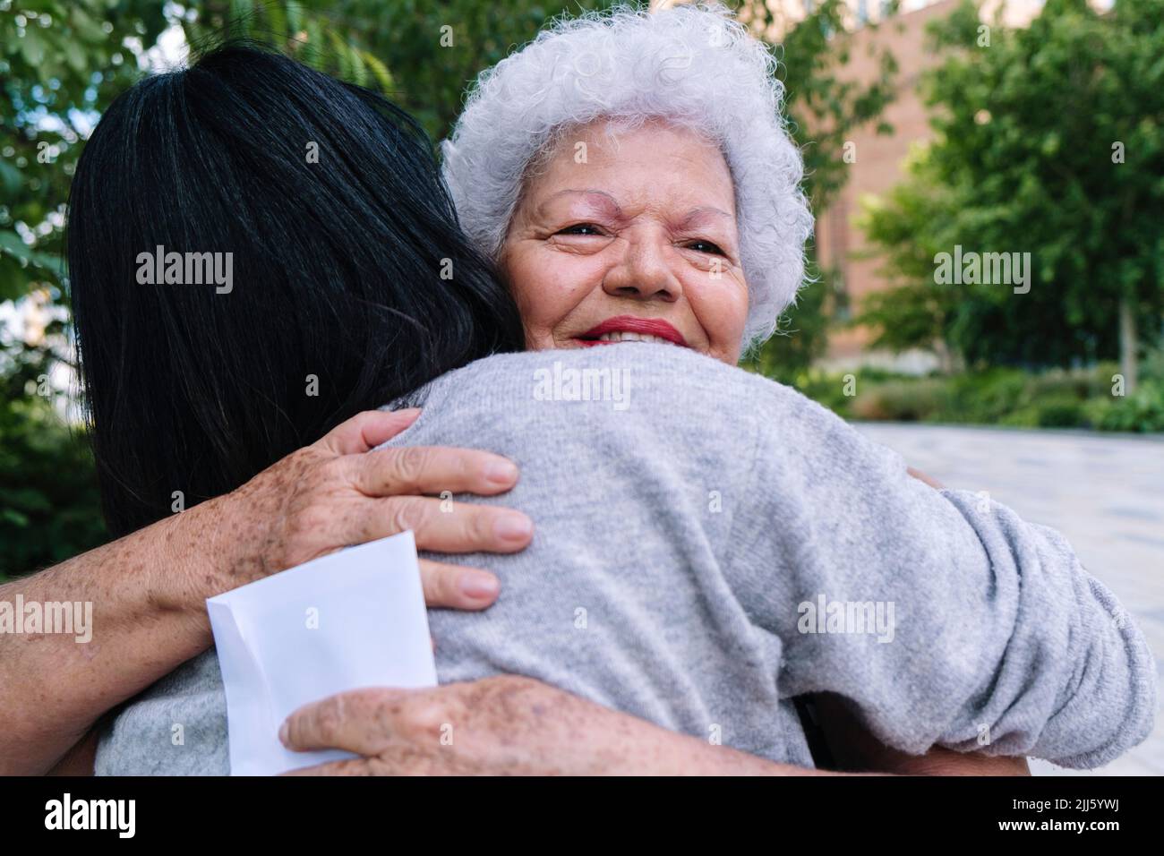 Daughter and mother hugging each other in park Stock Photo