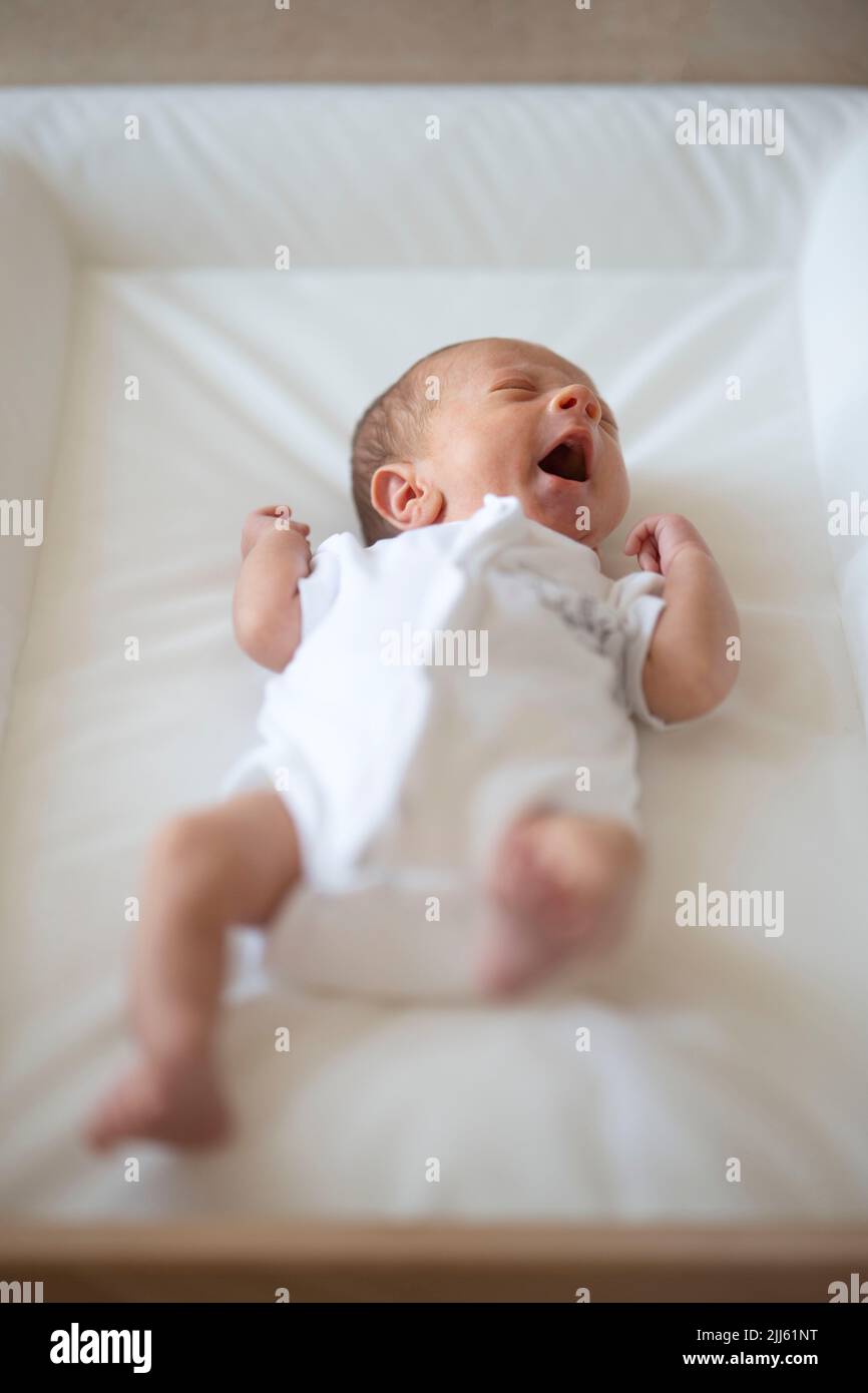 Agitated baby waving arms and legs while crying Stock Photo