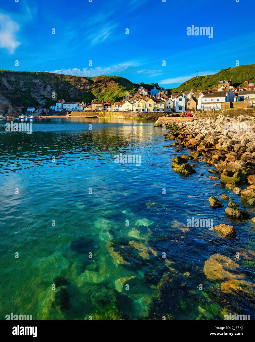 Staithes harbour on the North Yorkshire Coast of England. A beautiful summer morning with clear blue skies that really reflected well in the magnifice Stock Photo