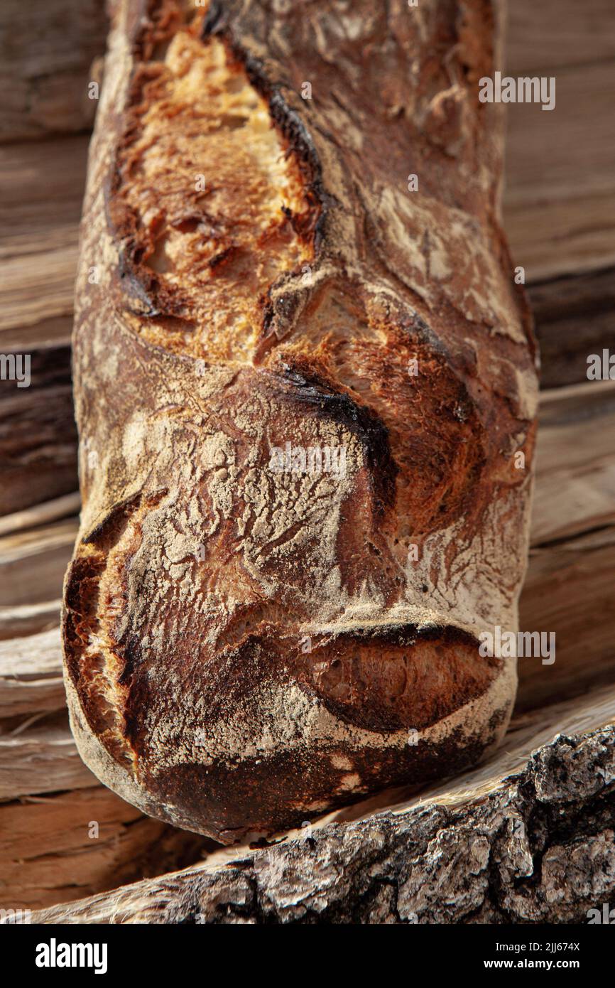 Close up of a rustic bread on wood logs Stock Photo