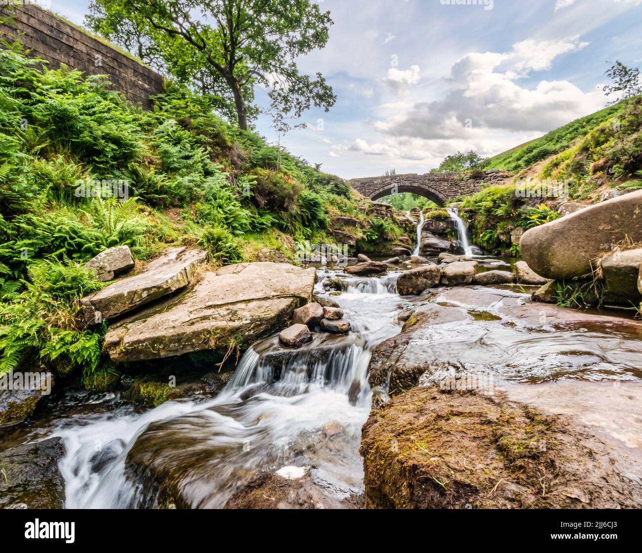 Waterfall stream & packhorse bridge where three counties of Derbyshire, Staffordshire & Cheshire meet, Three Shires Head, Peak District, England, UK Stock Photo