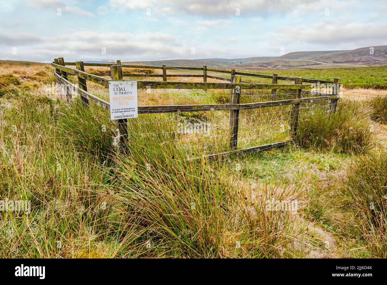 Fenced off secured site of old disused mine shaft in  moorland, Peak District, England, UK Stock Photo