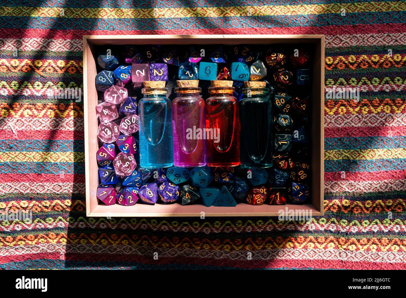 Overhead image of a dice tray filled with rpg role playing dice and potions bottles Stock Photo