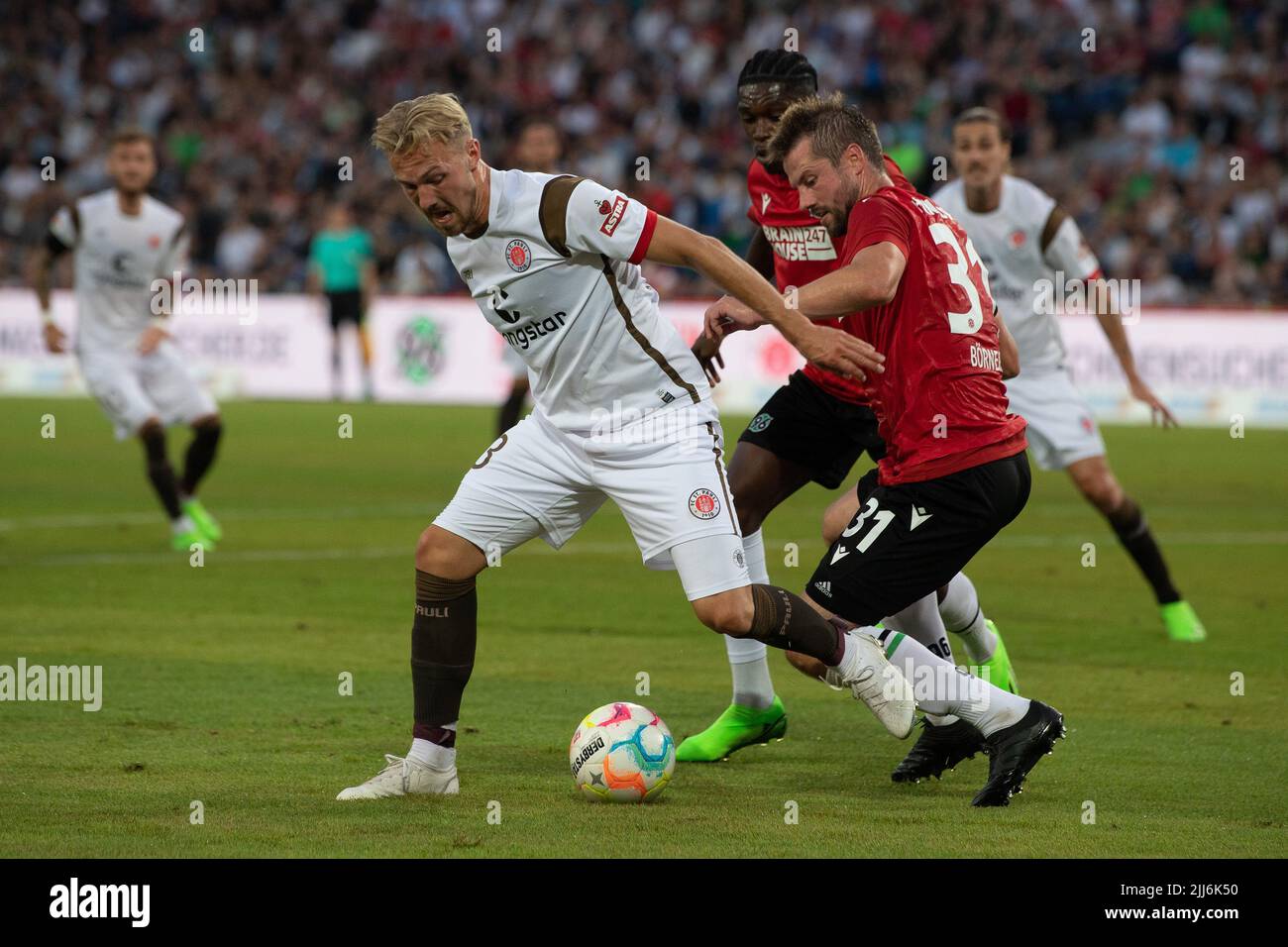 Hanover, Germany. 23rd July, 2022. Soccer: 2nd Bundesliga, Hannover 96 - FC St. Pauli, Matchday 2, Heinz von Heiden Arena. St. Pauli's Eric Smith (l) plays against Hannover's Julian Börner. Credit: Swen Pförtner/dpa - IMPORTANT NOTE: In accordance with the requirements of the DFL Deutsche Fußball Liga and the DFB Deutscher Fußball-Bund, it is prohibited to use or have used photographs taken in the stadium and/or of the match in the form of sequence pictures and/or video-like photo series./dpa/Alamy Live News Stock Photo