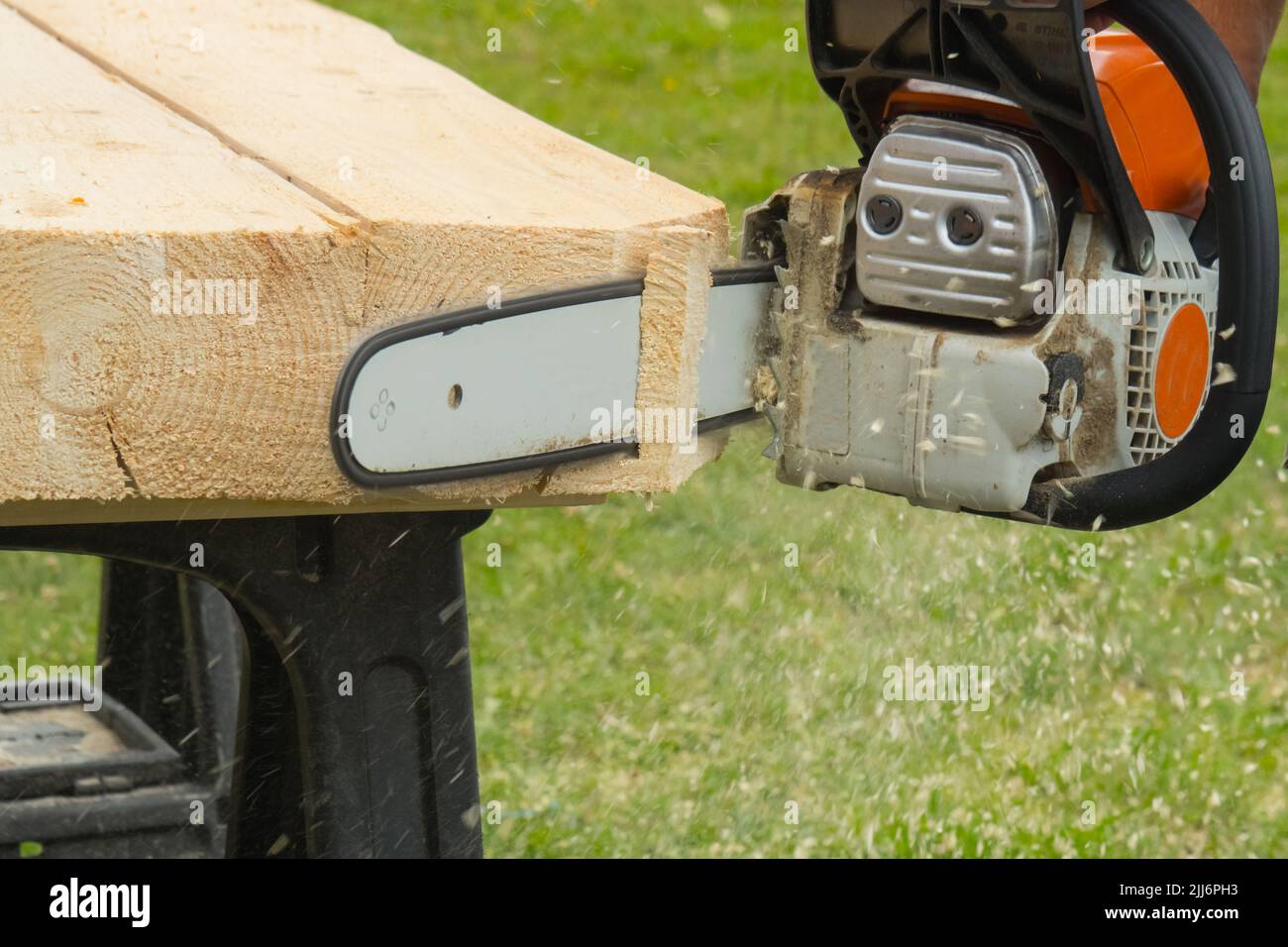 A construction worker cutting boards with a chainsaw in construction