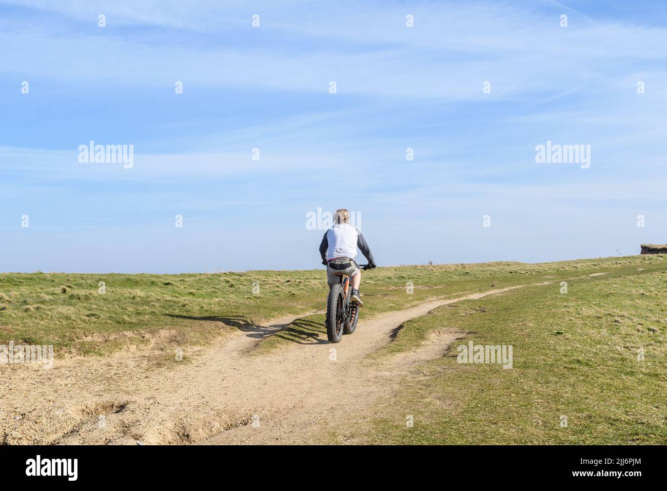 A back view of a middle-aged male riding a bicycle Stock Photo - Alamy