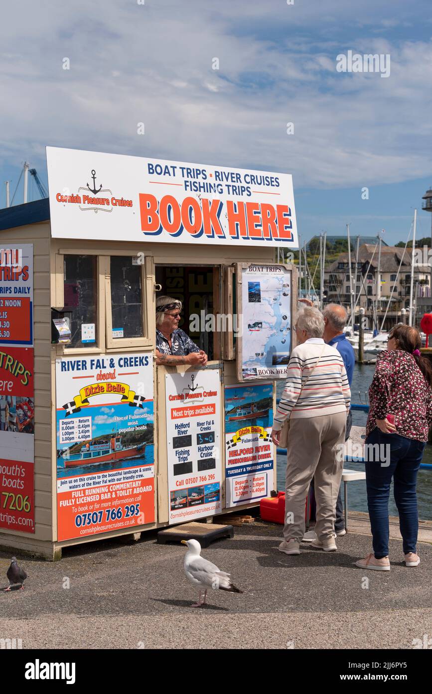 Falmouth, Cornwall, England, UK. 2022. Visitors to Falmouth booking a boat trip from a ticket office on the waterfront. Stock Photo