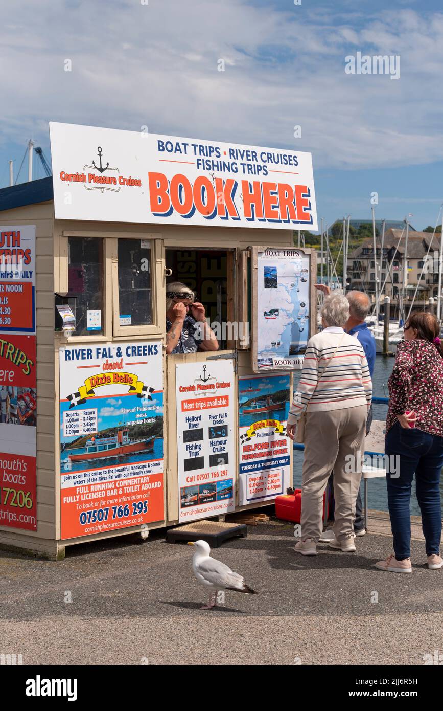 Falmouth, Cornwall, England, UK. 2022. Visitors to Falmouth booking a boat trip from a ticket office on the waterfront. Stock Photo