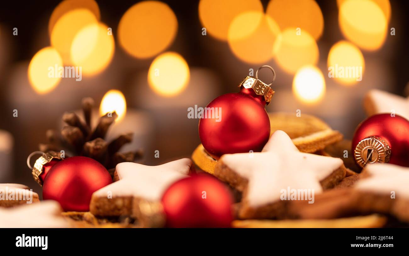 A selective shot of many cinnamon star cookies with red Christms tree toys Stock Photo