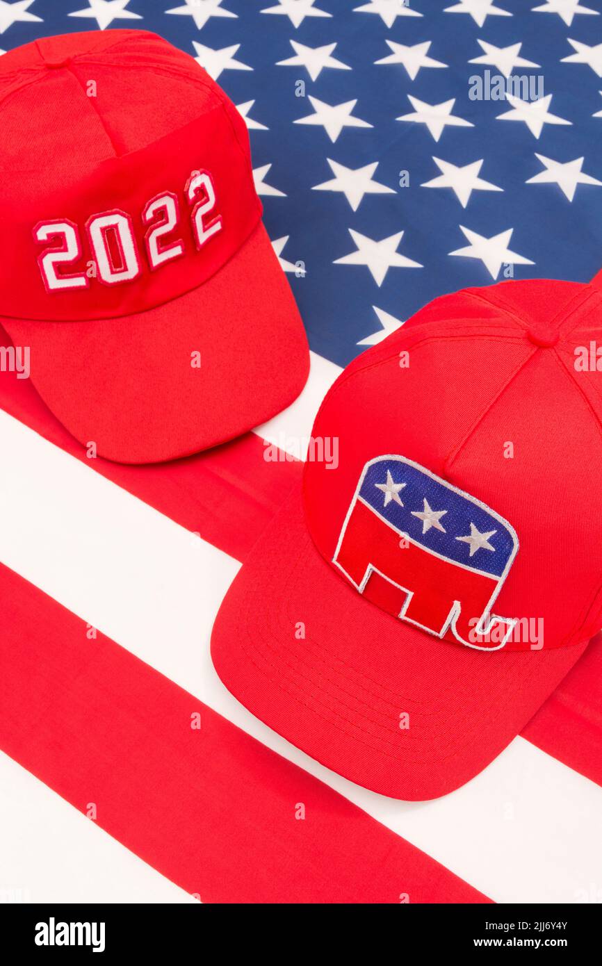 Red MAGA-type cap with 2022 and Republican Elephant & US Stars and Stripes flag. For 2022 US Midterm elections in November & Republican Red Wave. Stock Photo