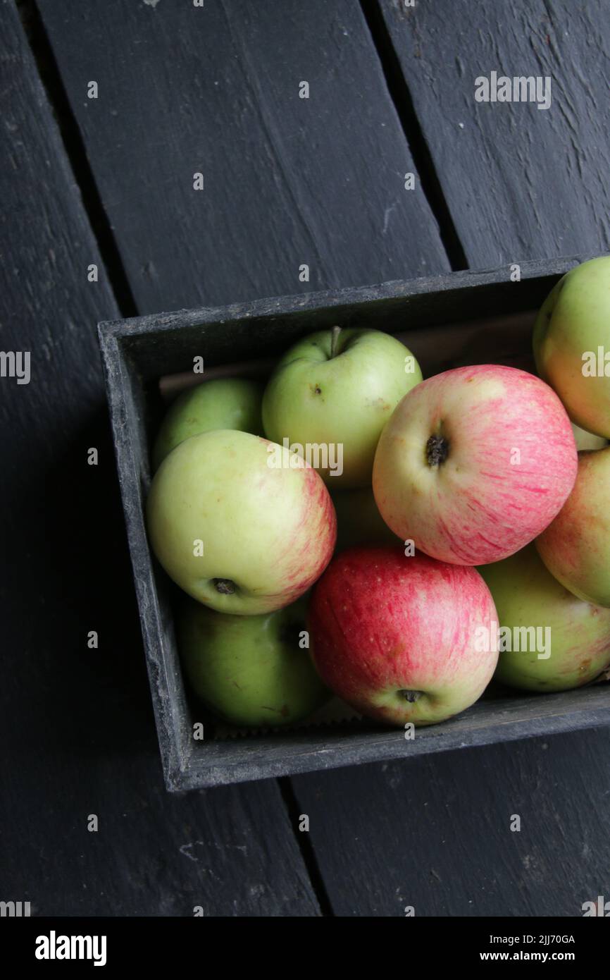 Fresh organic Ripe green apples box on wooden table Stock Photo by