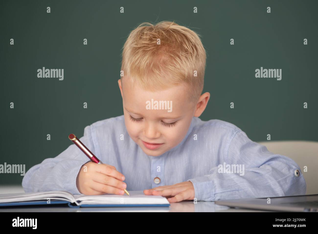 Child at school. Kid writing in notebook in class. Kid is learning in