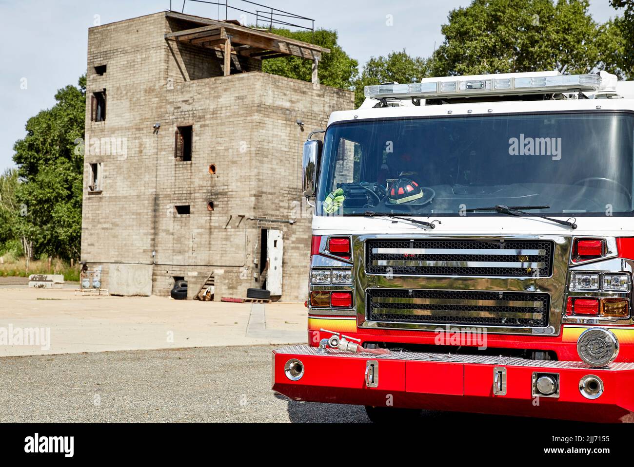 Fire Truck parked by a fire training building Stock Photo