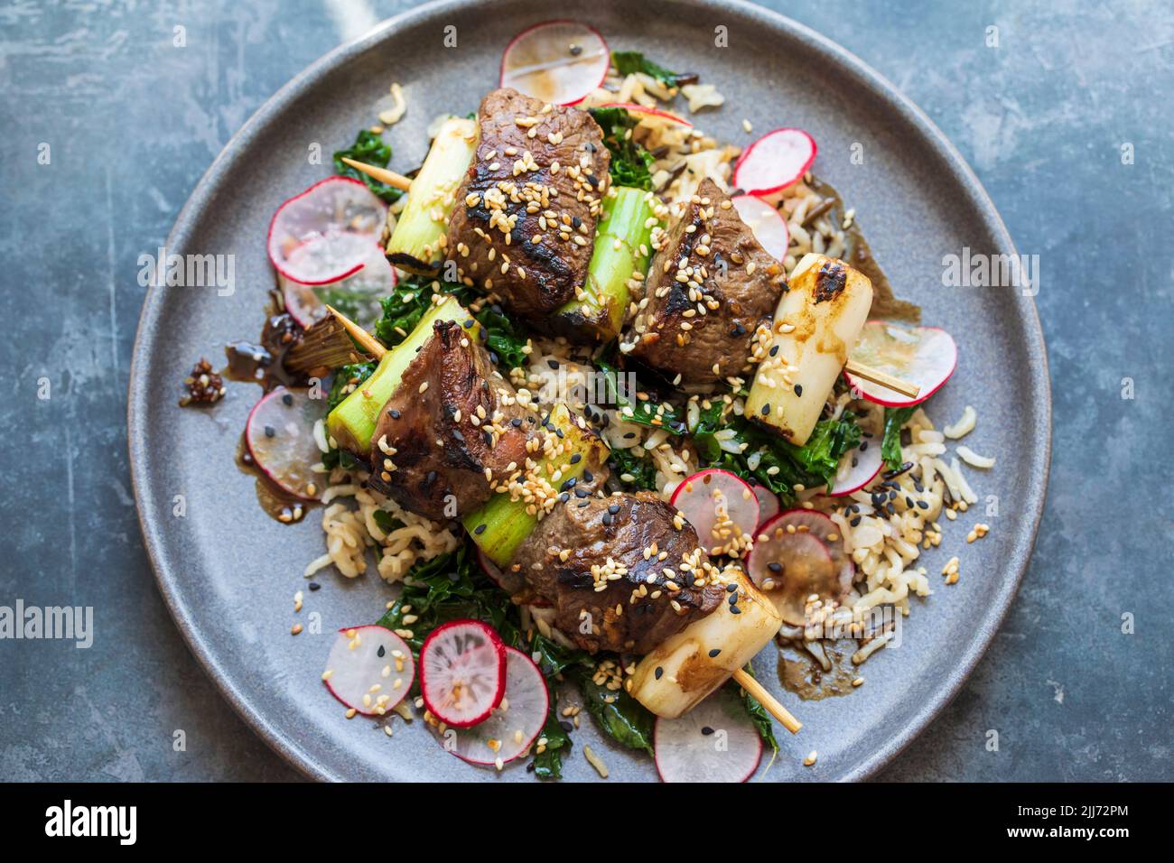 Beef steak skewers with rice, kale and radishes Stock Photo