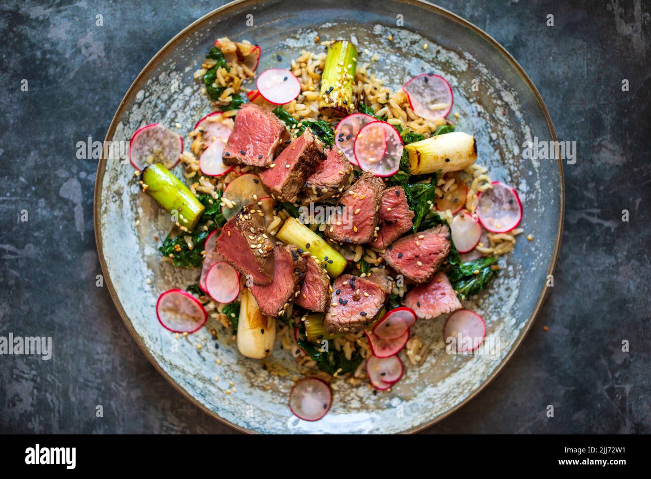 Beef steak with rice, kale and radishes Stock Photo