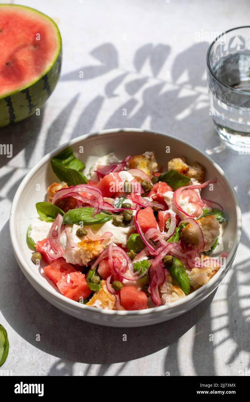 Summer salad with watermelon, buratta, basil and pickled onions Stock Photo