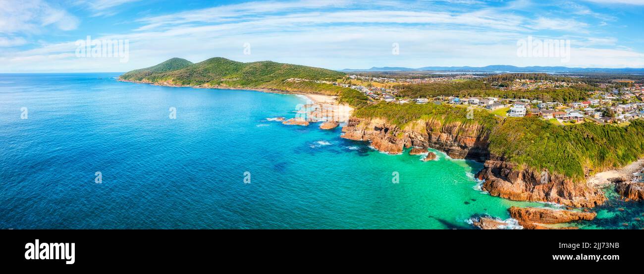 Cliffs and rocks of Pacific ocean coast around Burgess beach in Forster town of Australia - aerial panorama. Stock Photo