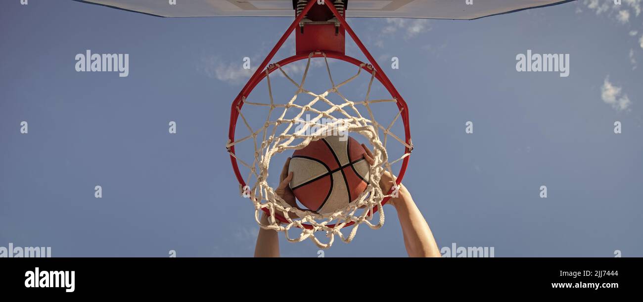 basketball ball dunk through net ring with hands, winning Stock Photo