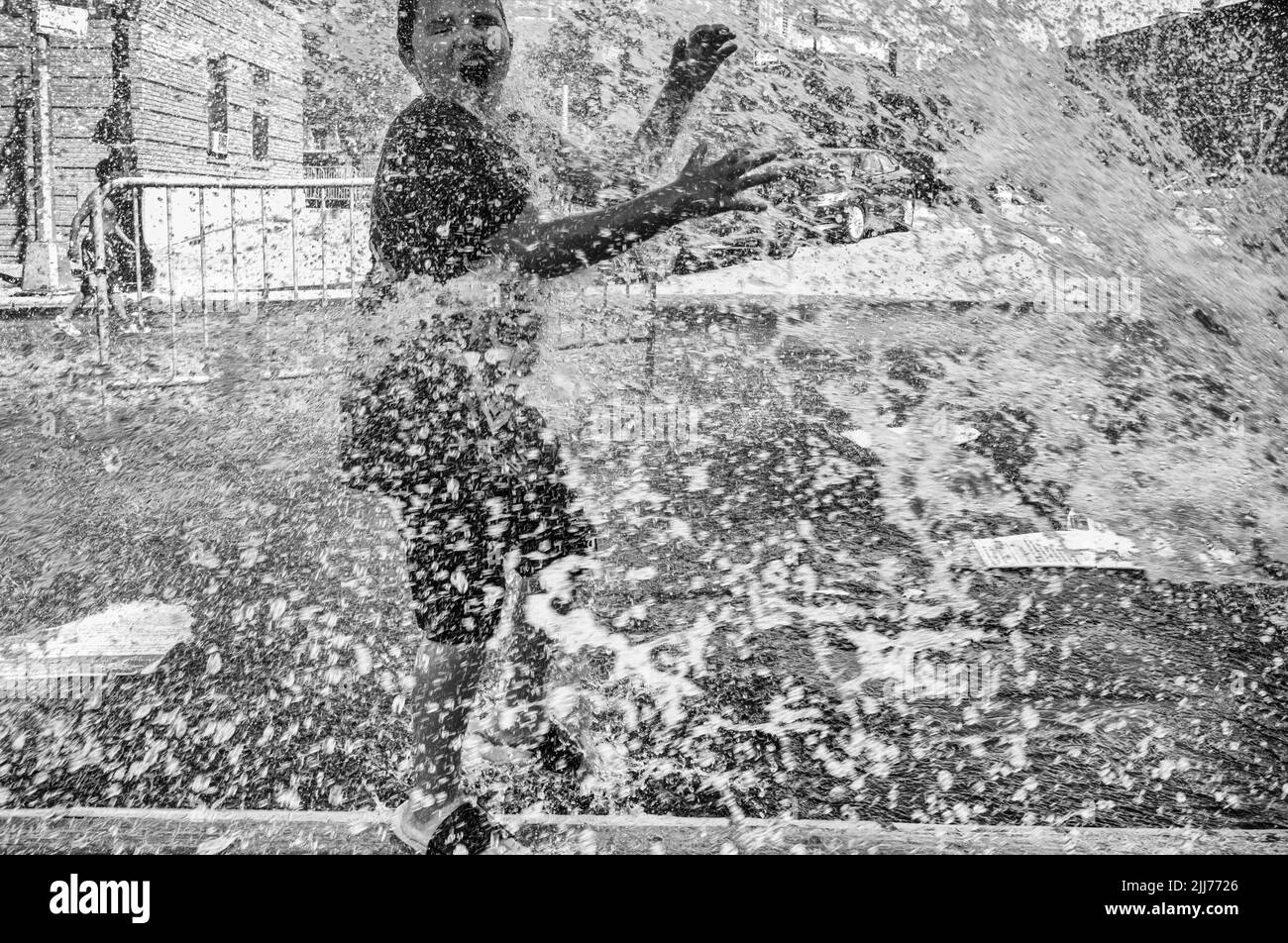 New York, New York, USA. 23rd July, 2022. Children play in the spray from the fire hydrant in the Bronx section of New York. New York temps reached the upper 90's with the heatwave expected to soar three the weekend. (Credit Image: © Brian Branch Price/ZUMA Press Wire) Stock Photo