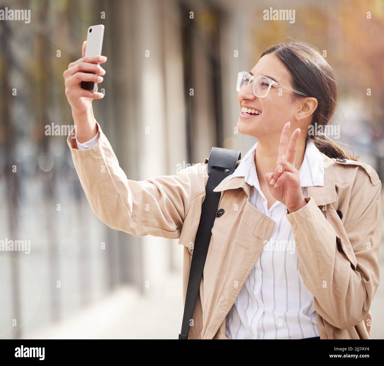 Enjoying every minute. a young woman using a smartphone and taking a selfie while out in the city. Stock Photo