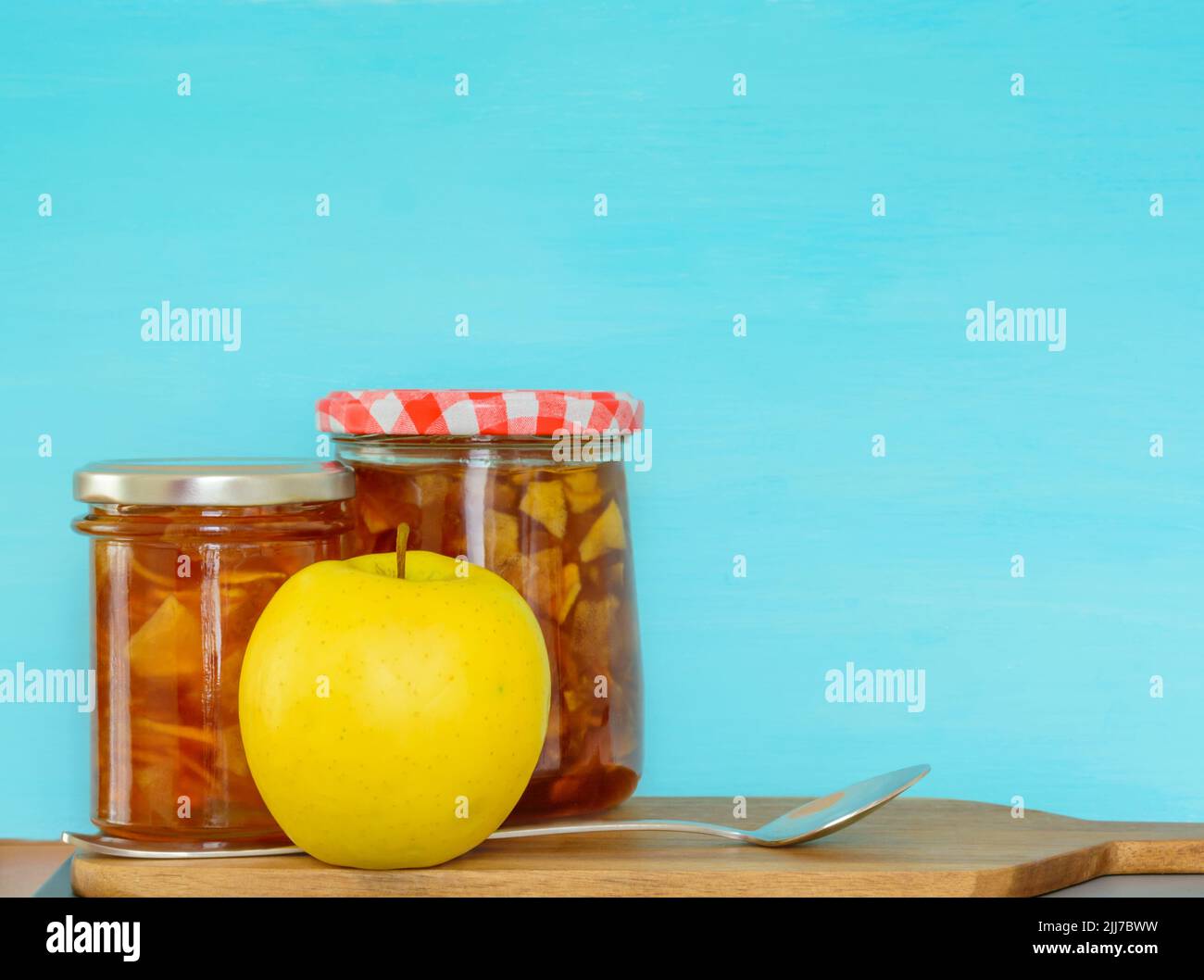 Background with two jars of jam and yellow apple Stock Photo