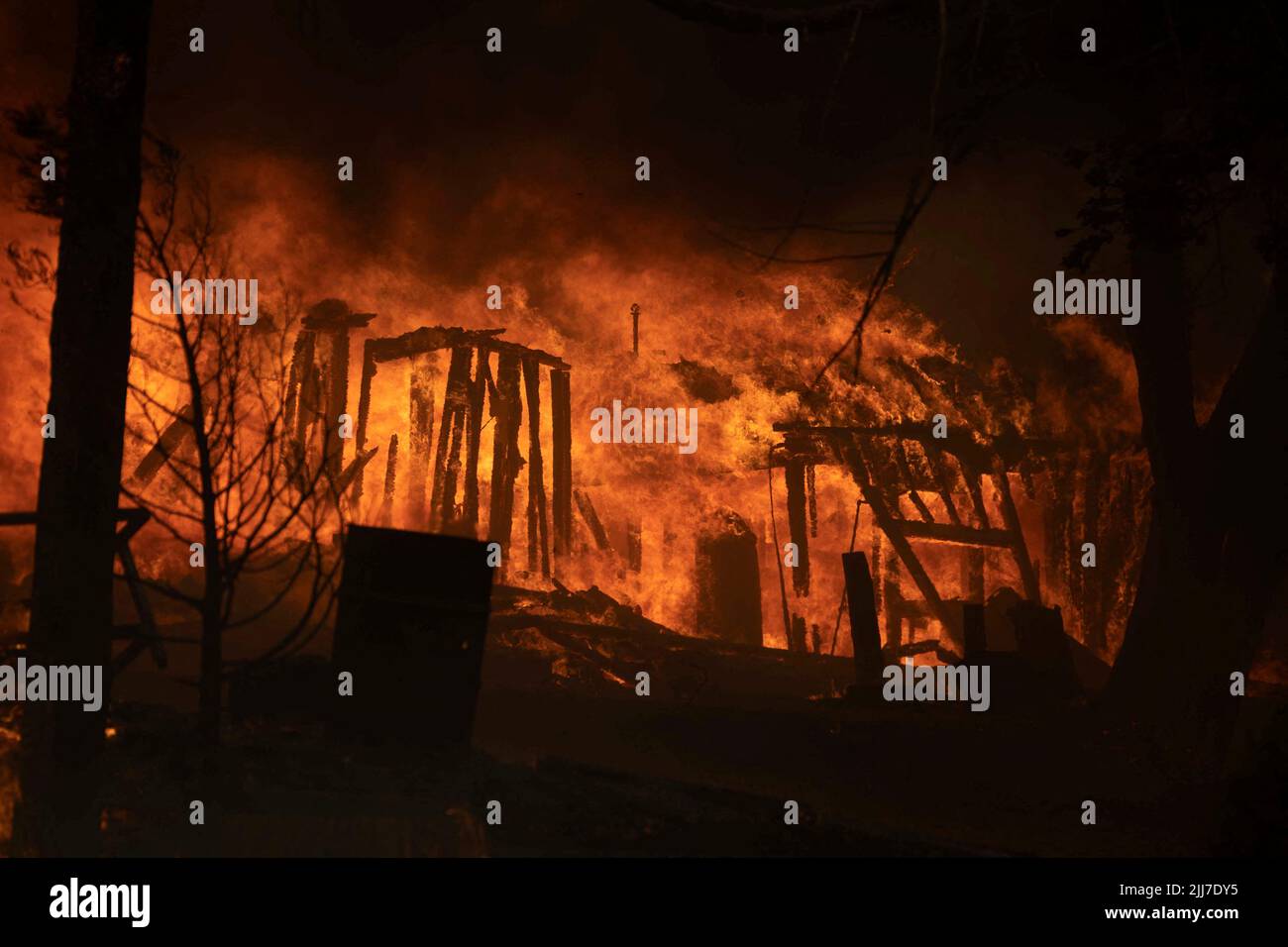 A house is seen on fire as the Oak Fire burns burns near Darrah in Mariposa County, California, U.S. July 23, 2022. REUTERS/Carlos Barria Stock Photo