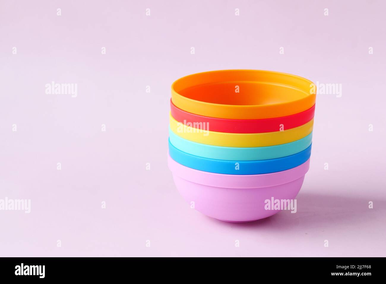 putting empty colorful bowl on table Stock Photo