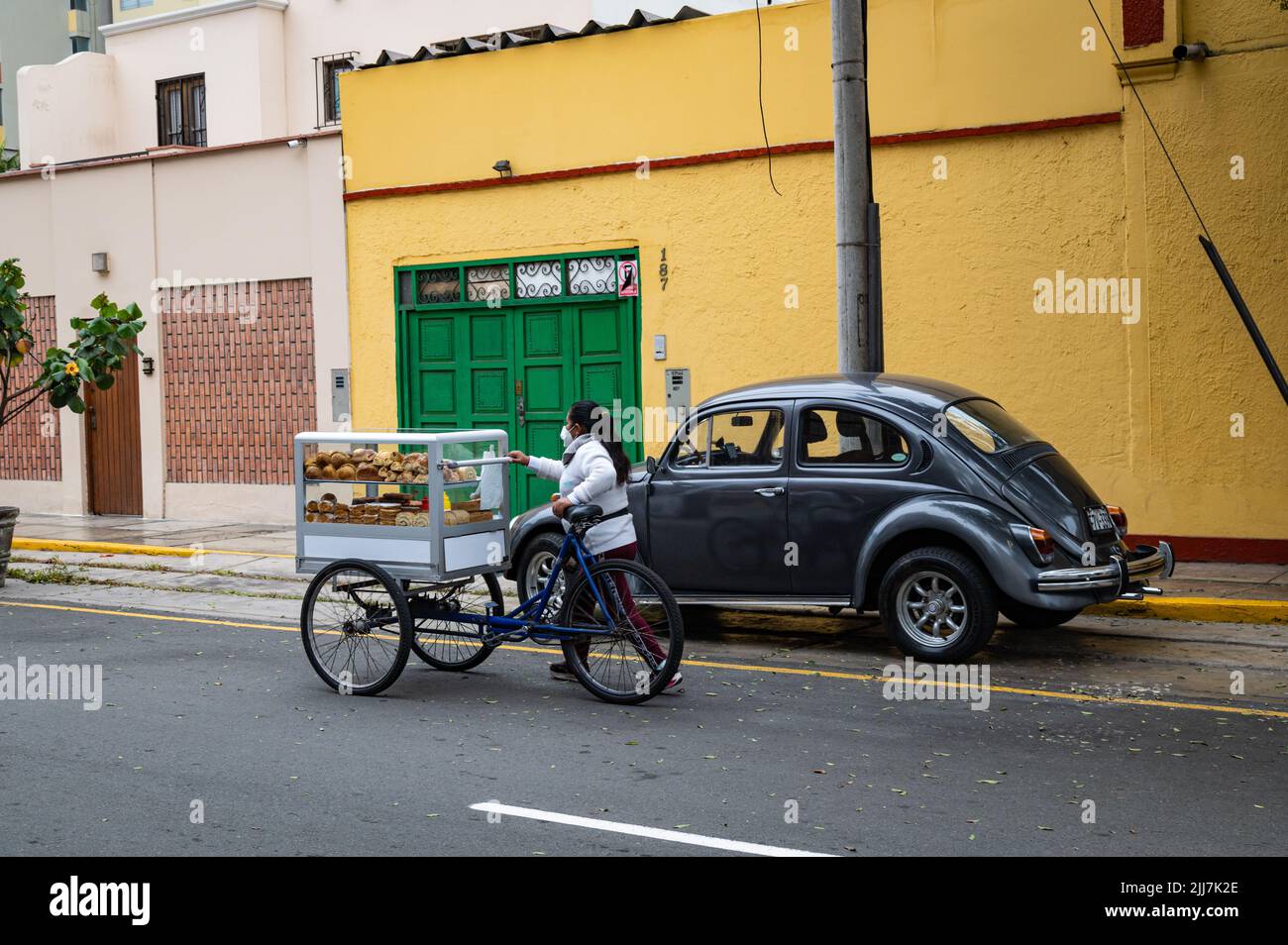 Photo of a young woman vendor pushing her pastry cart in the Miraflores district. Stock Photo