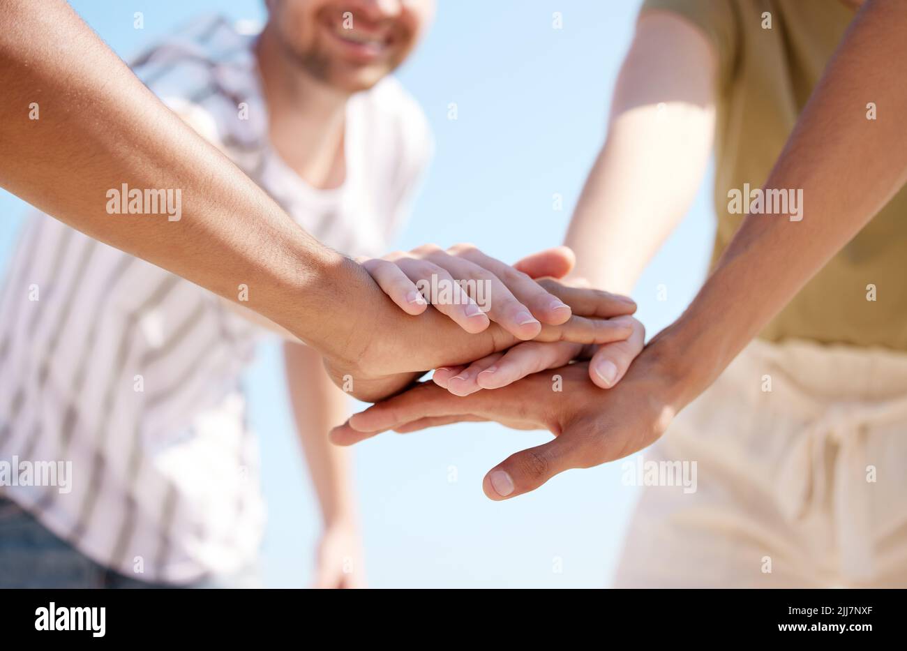 Lets do this. a group of unrecognizable people stacking their hands ...