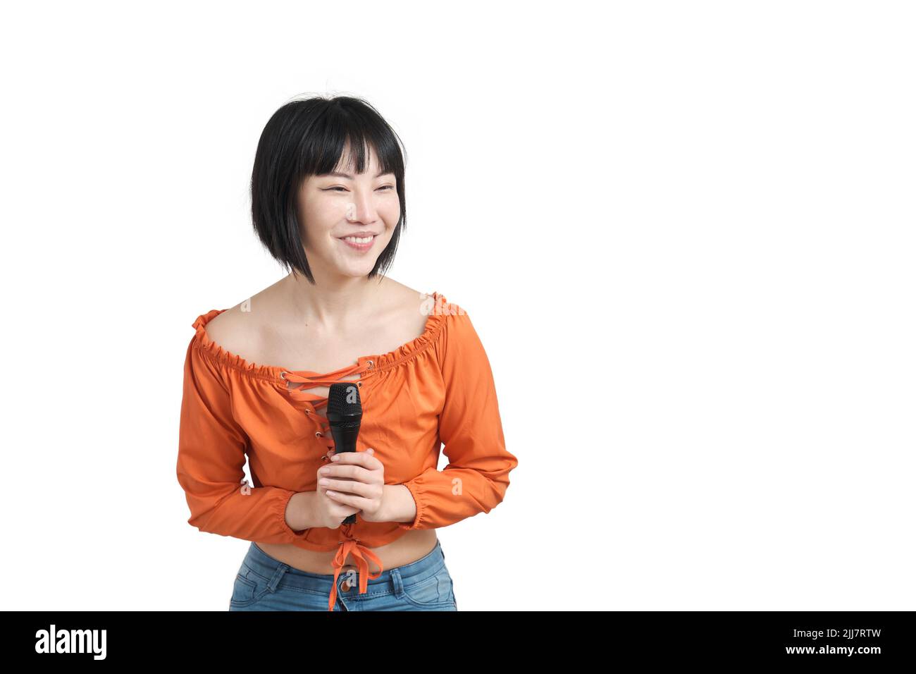 Young asian woman talking with her audience through microphone, isolated. Stock Photo