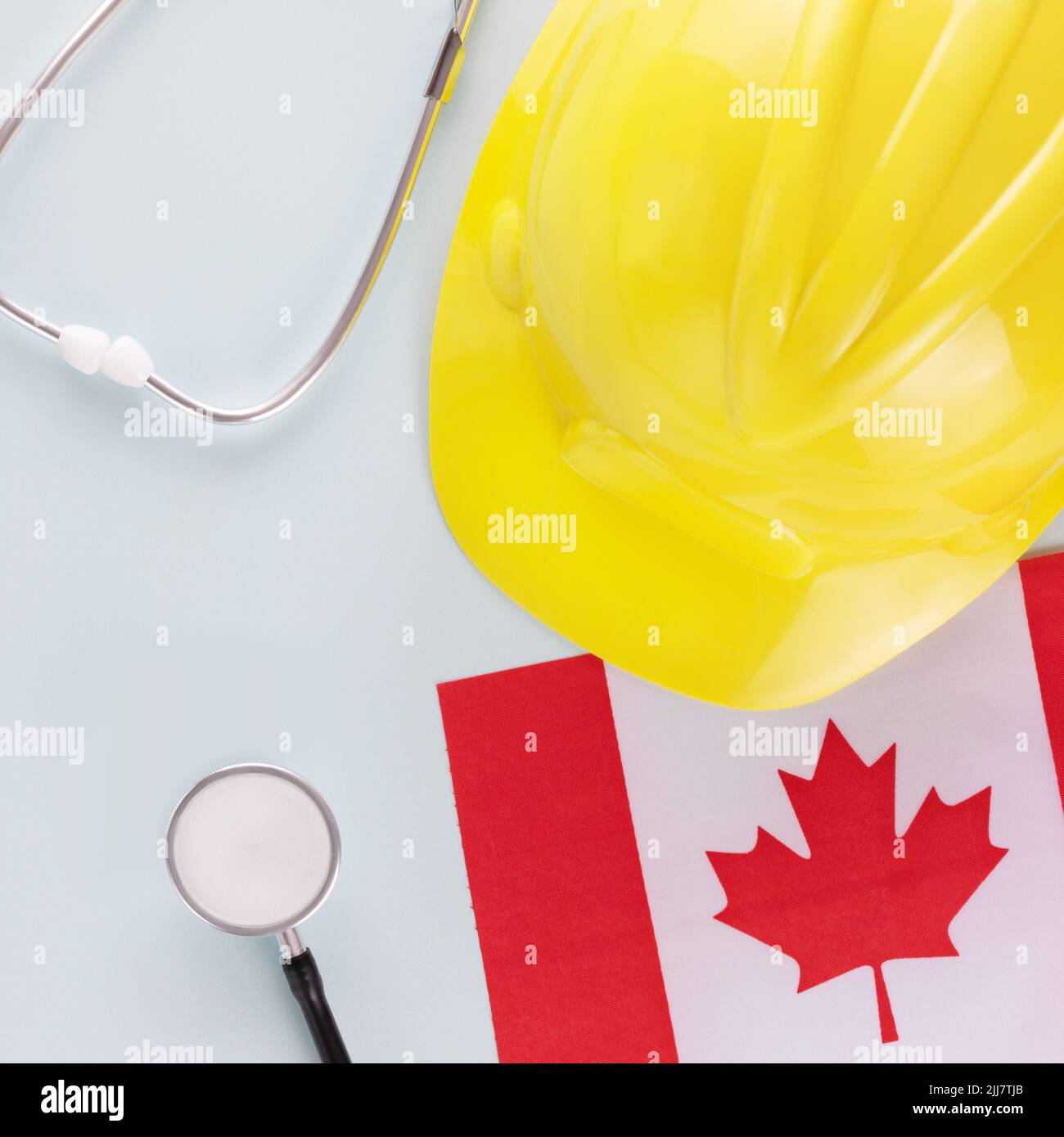 Canadian flag, stethoscope and hardhat on a blue background. Medical