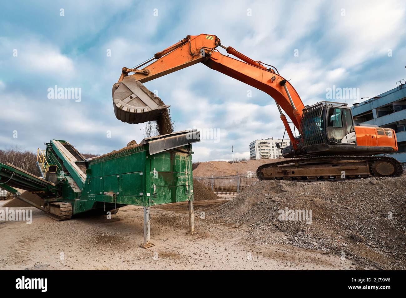Excavator loads soil in mobile crushing and sorting complex Stock Photo