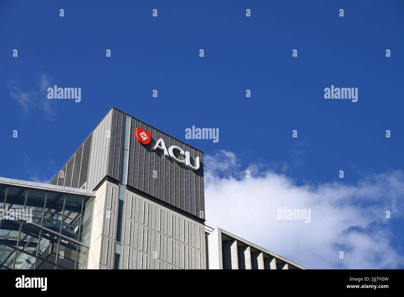 Australian Catholic University logo, featuring red shield with a cross, atop the Daniel Mannix Building at ACU's Melbourne campus Stock Photo