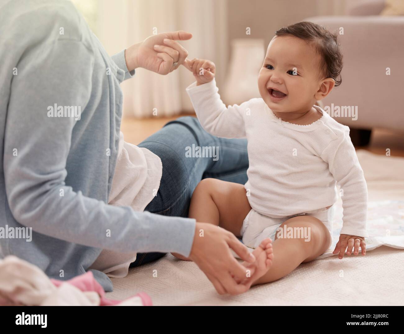 Adorable doesnt begin to describe her. an adorable baby girl sharing a playful moment with her mother at home. Stock Photo