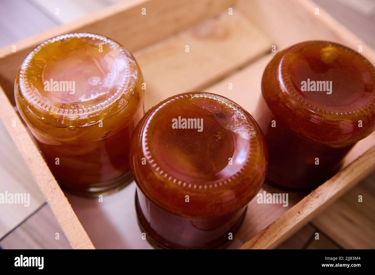 Top view of homemade apricot jam with pits and pieces of canned peaches