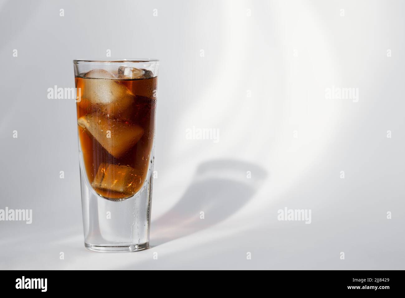 Glass of cola with ice on a white background Stock Photo - Alamy