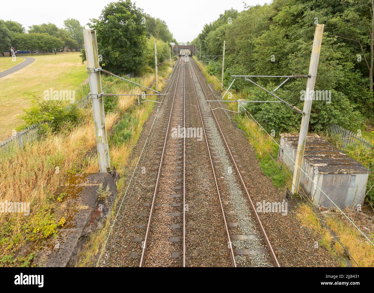 train tracks at longport station going of to the distance towards stoke on trent showing the Overhead line equipment shot from above Stock Photo