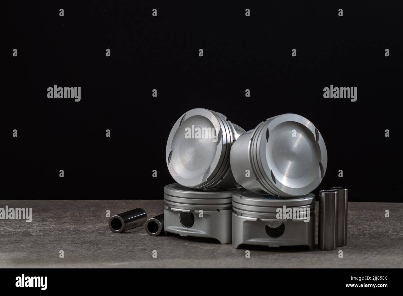 Set of new car pistons and valves on black background, car repair parts, copy space. Stock Photo