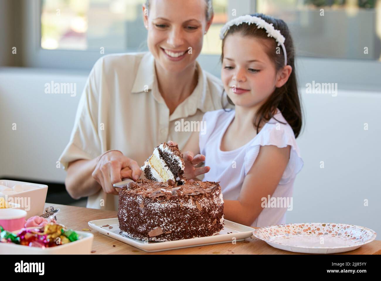 You get the first piece. a little girl celebrating her birthday at home. Stock Photo