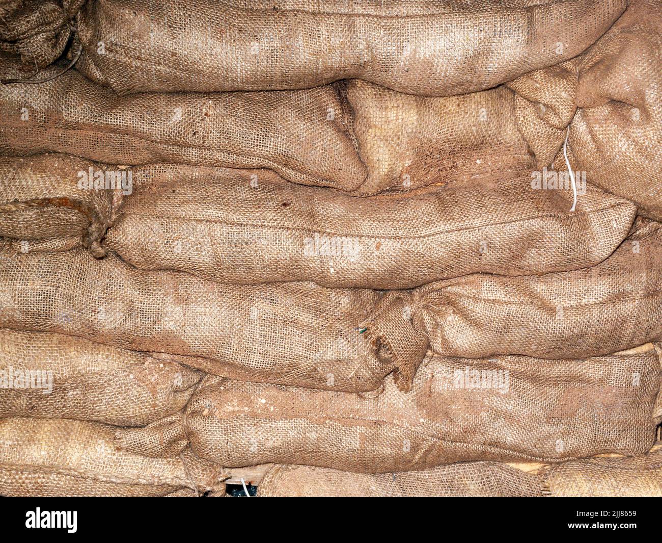 Sandbags background stacked in a heap for use as flood defence or for the military as a barricade, stock photo image Stock Photo